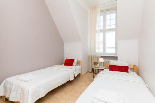 two beds in a room with white walls and a window at Suurkarja Apartment in Tallinn