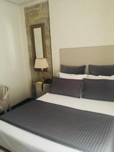 a bedroom with a large bed with a mirror at Hotel Central Jardim in Geres
