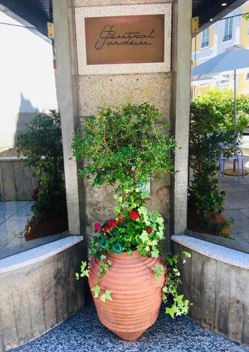 a large flower pot sitting in front of a store at Hotel Central Jardim in Geres
