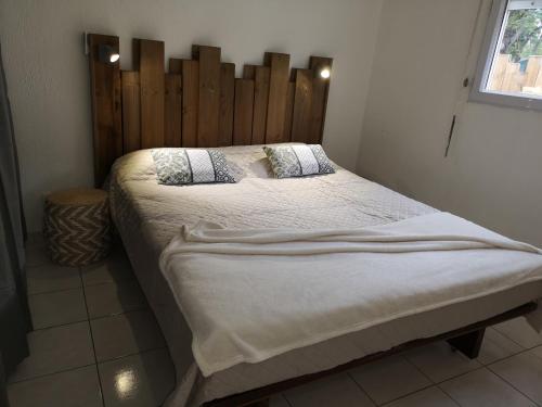 una camera con un grande letto con testiera in legno di Le PLAYA LODGE a Saint-François