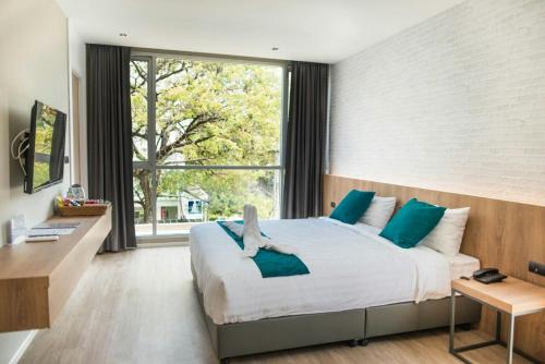 a bedroom with a large bed and a large window at B Stay Hotel in Bangkok