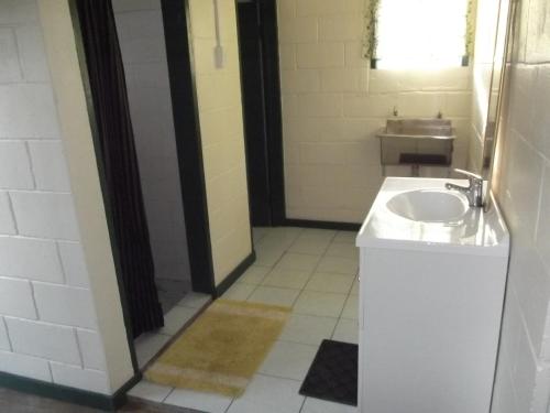 a bathroom with a sink and a mirror at Green Lodge Holiday Homes in Nuku‘alofa
