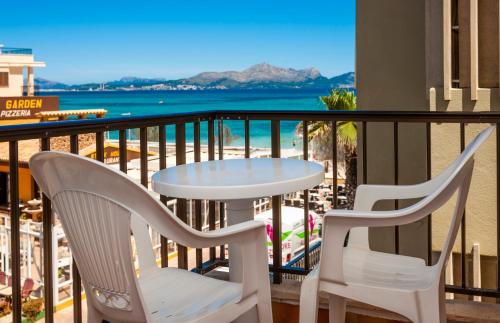 two chairs and a table on a balcony with the beach at Apartamentos Charlys Can Picafort in Can Picafort