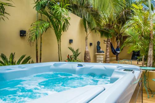 a hot tub in a courtyard with palm trees at Bamboo Bonaire Boutique Resort in Kralendijk