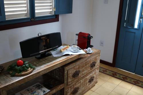 a table with a television on top of a dresser at Chalé Clássico in Lavras Novas
