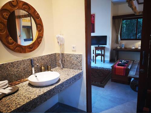 a bathroom with a sink and a mirror at Villa with private pool at Villa Nirvana Ubud in Ubud