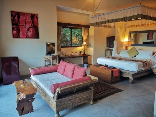 a bedroom with two beds and a couch and a bed at Villa with private pool at Villa Nirvana Ubud in Ubud