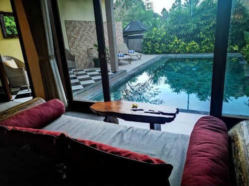 a living room with a couch and a swimming pool at Villa with private pool at Villa Nirvana Ubud in Ubud