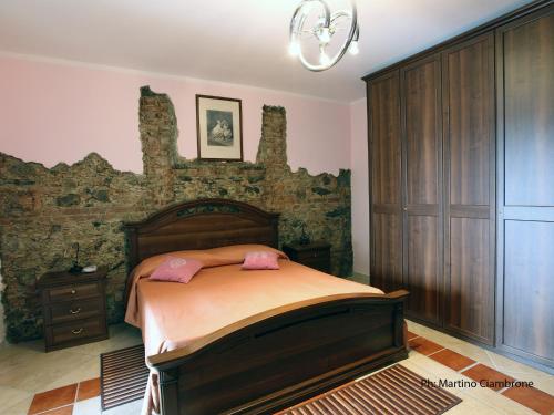 Bed & Breakfast Garrupa في Marcellinara: غرفة نوم بسرير وجدار حجري