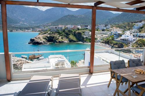 a balcony with a table and chairs and a view of the water at Villa Vasilis in Balíon