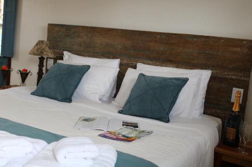 a bed with towels and a book on it at Chalé Clássico in Lavras Novas