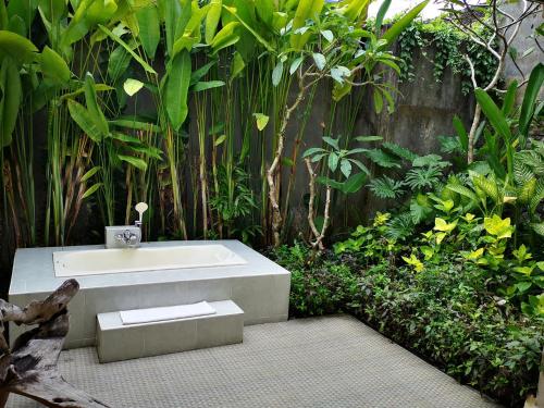 a bath tub in the middle of a garden at Villa with private pool at Villa Nirvana Ubud in Ubud