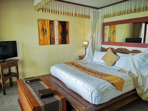 a bedroom with a large bed and a television at Villa with private pool at Villa Nirvana Ubud in Ubud