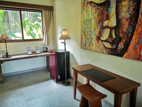a room with a table and a painting on the wall at Villa with private pool at Villa Nirvana Ubud in Ubud