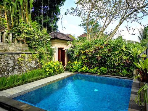 a swimming pool in front of a house at Villa with private pool at Villa Nirvana Ubud in Ubud