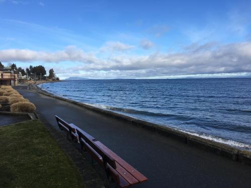 a bench sitting next to a body of water at Casa Grande Inn in Qualicum Beach