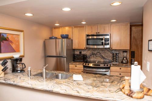 a kitchen with a stainless steel refrigerator and a sink at 111 Vail International Condo in Vail