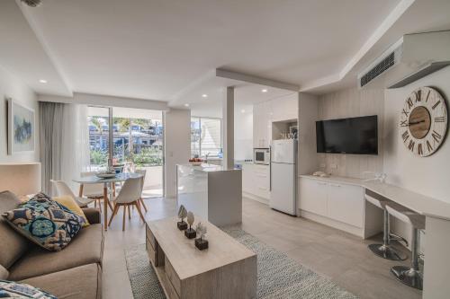 a kitchen and living room with a couch and a table at Hotel Laguna in Noosa Heads