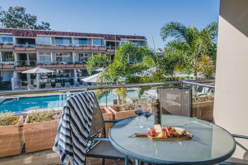 a table with a plate of food and a bottle of wine at Hotel Laguna in Noosa Heads