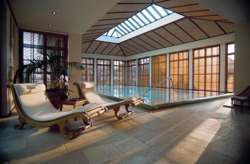a large room with a swimming pool and two chairs at Hotel Stadt Hamburg in Westerland (Sylt)