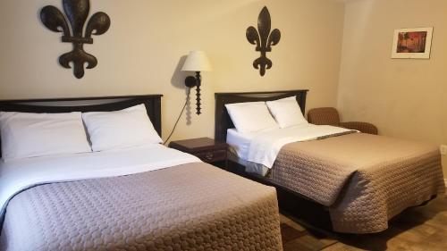 a hotel room with two beds and a lamp at Rothesay Motel in Rothesay