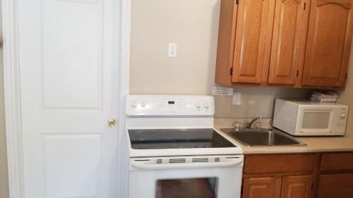 a kitchen with a white stove top oven next to a sink at Rothesay Motel in Rothesay