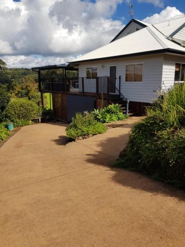 uma casa branca com um alpendre e uma entrada em Tambo Tranquility em Mount Tamborine