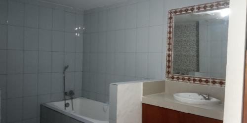 a bathroom with a tub and a sink and a mirror at Vico hotel in Nusa Dua