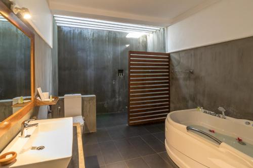 a bathroom with a large tub and a sink at Camellia Resort and Spa in Sigiriya