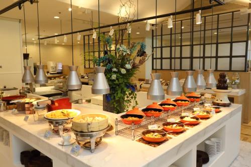 una línea de buffet con tazones y platos de comida en Loisir Hotel Toyohashi en Toyohashi