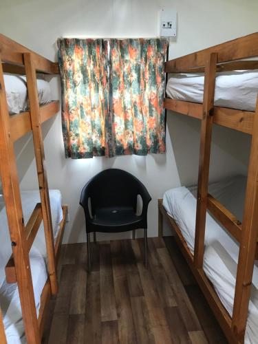 a room with two bunk beds and a chair at Lake Albert Caravan Park in Meningie