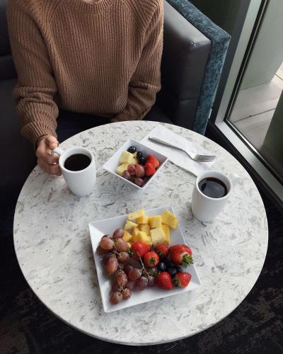 a person sitting at a table with a plate of fruit at Hyatt Place Glendale/Los Angeles in Glendale