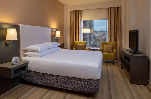 a hotel room with a large white bed and a television at Hyatt at Olive 8 in Seattle