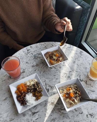 a person sitting at a table with three bowls of food at Hyatt Place Glendale/Los Angeles in Glendale