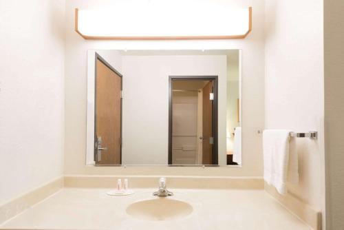 uma casa de banho com um lavatório e um espelho grande em Super 8 by Wyndham Greenfield em Greenfield