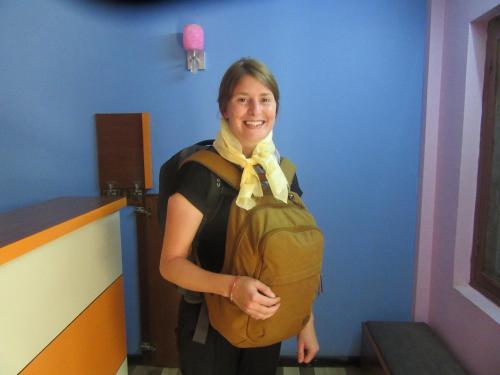 a woman with a backpack standing in a room at STUPA VIEW INN in Kathmandu