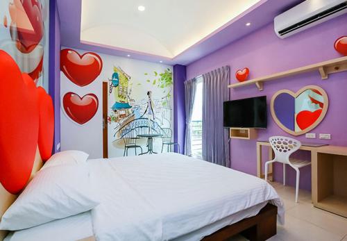 a bedroom with a bed with hearts on the wall at Mr. Sloth & Mrs. Cat B&B in Taitung City