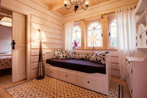 a bedroom with a bed in a room with wooden walls at Gorce Oasis in Szlembark