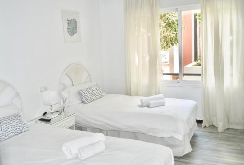 biały pokój z 2 łóżkami i oknem w obiekcie Puerto Banus with private garden w Marbelli
