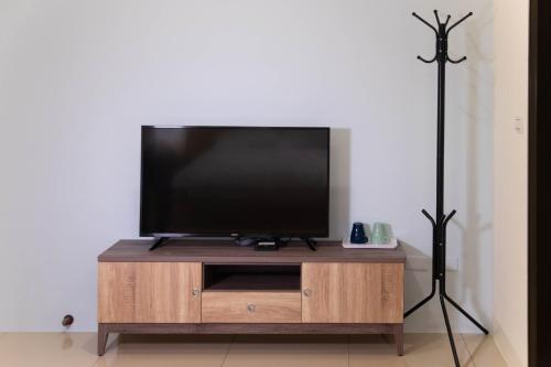 a flat screen tv sitting on top of a wooden entertainment center at Tung Shiang Homestay in Sanyi