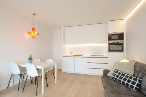 a kitchen and living room with a table and a couch at Studio zwembad met frontaal zeezicht in Ostend