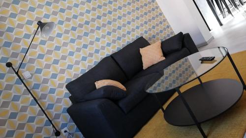 - un salon avec un canapé noir et une table en verre dans l'établissement les Pénates appartement terrasse, à Saint-Max