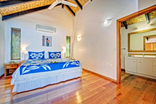 a bedroom with a bed and a wooden floor at Tamanu Beach in Arutanga