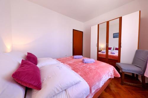 a bedroom with a bed and a chair and a mirror at Apartments Anka in Rtina