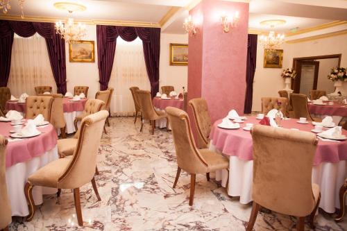 uma sala de jantar com mesas e cadeiras com toalhas de mesa cor-de-rosa em Royal Boutique Mangalia Breeze em Mangalia
