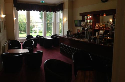 a room with chairs and a bar with a window at Broughton Craggs Hotel in Cockermouth