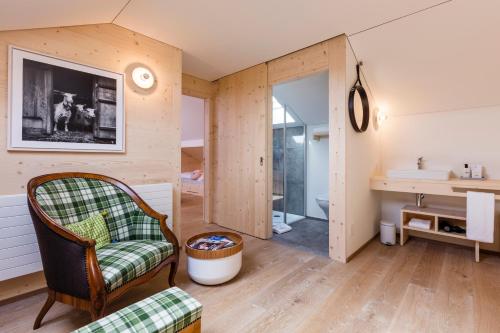 a living room with a chair and a sink at Neuhof Gäste-& Schokohaus in Appenzell