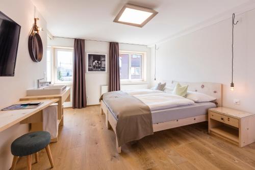 a bedroom with a bed and a desk in it at Neuhof Gäste-& Schokohaus in Appenzell
