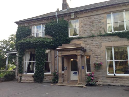 a brick house with ivy growing on it at Broughton Craggs Hotel in Cockermouth
