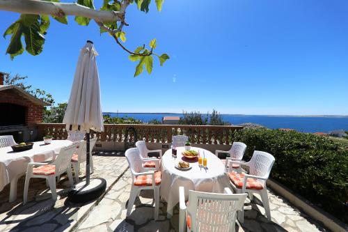 a table and chairs and an umbrella on a patio at Apartments Anka in Rtina
